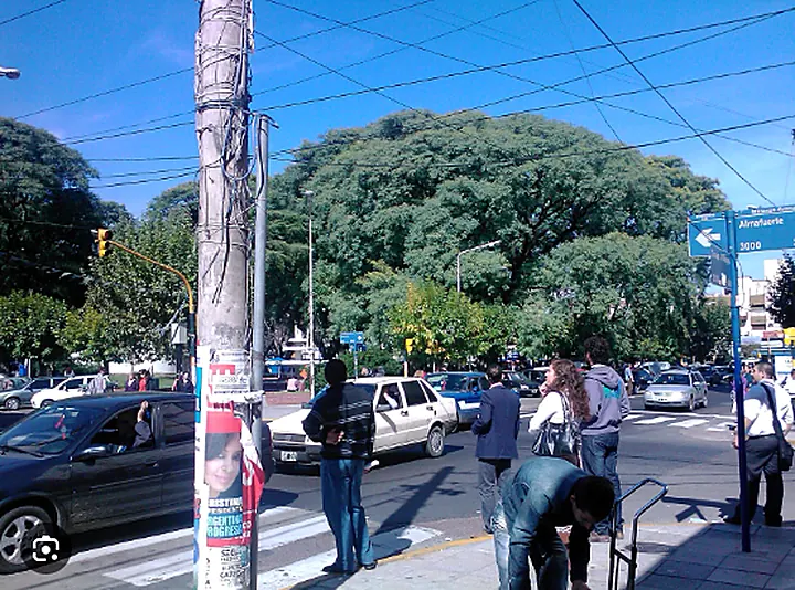 Esquina urbana y cartel nomenclador de Almafuerte en La Matanza con circulación peatonal y vehicular