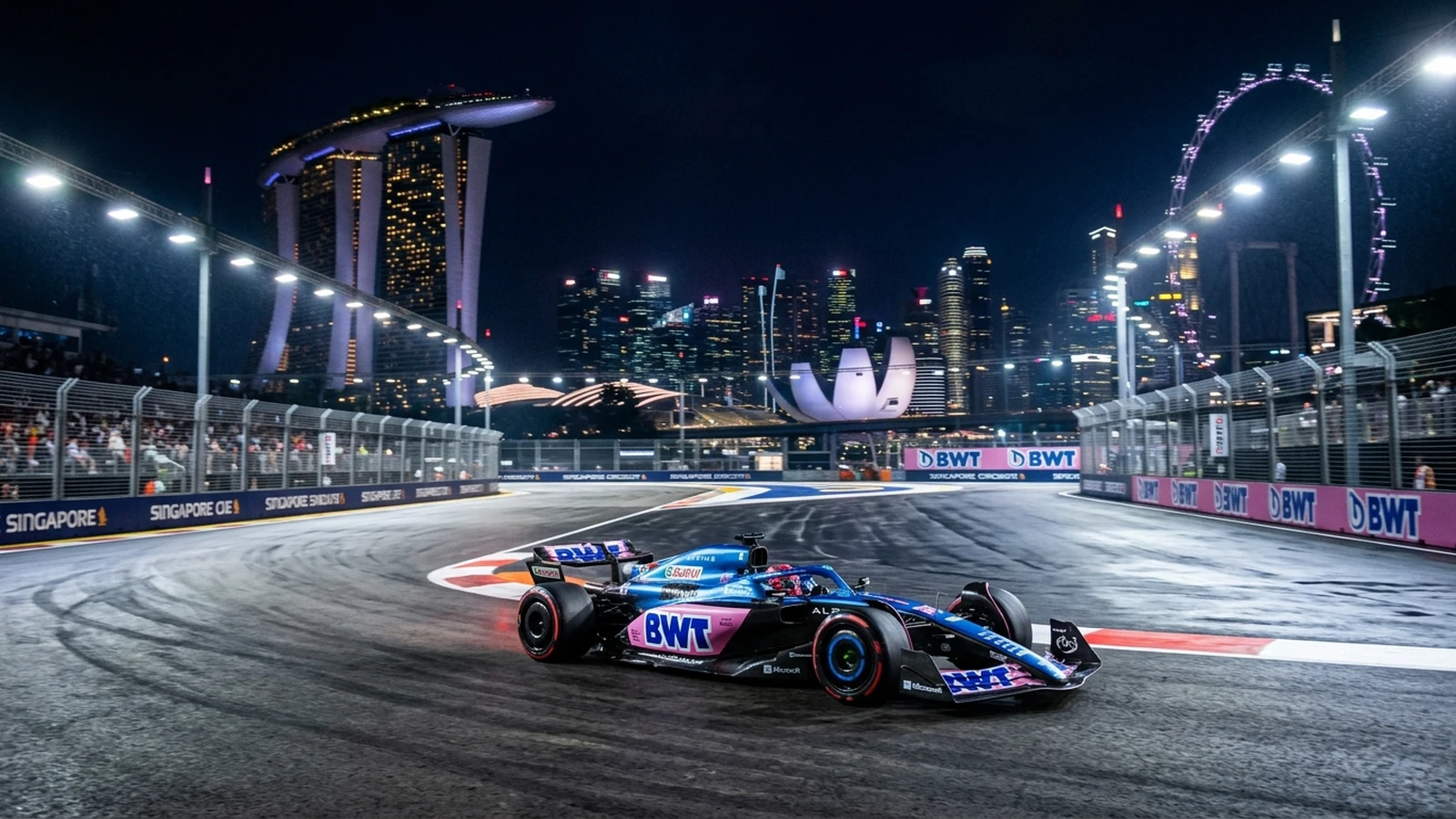 Monoplaza de Fórmula 1 de Alpine acelerando de noche en el circuito callejero de Marina Bay con rascacielos iluminados