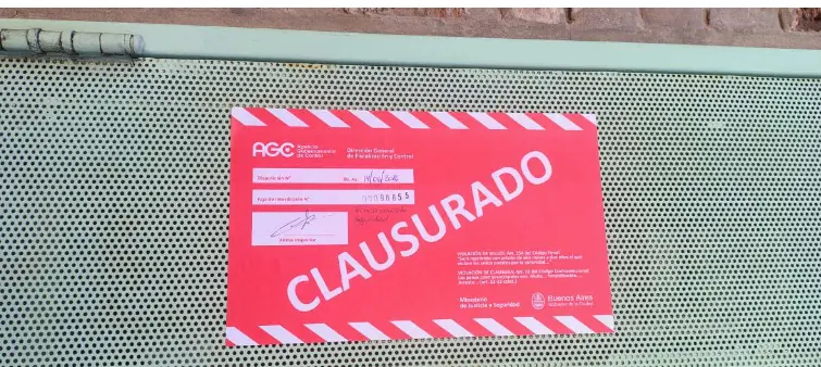 Faja oficial de clausura total colocada por la Agencia Gubernamental de Control sobre el portón de ingreso