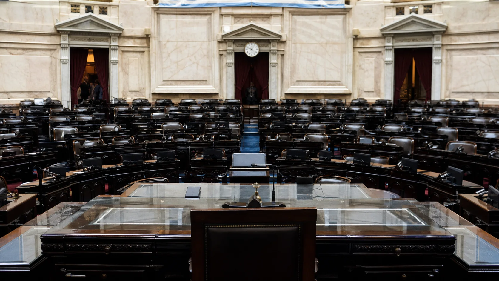 Recinto legislativo preparado para una sesión con bancas y pantallas de votación