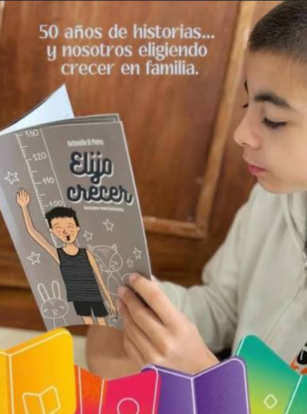 Un niño sostiene y lee un ejemplar de Elijo Crecer