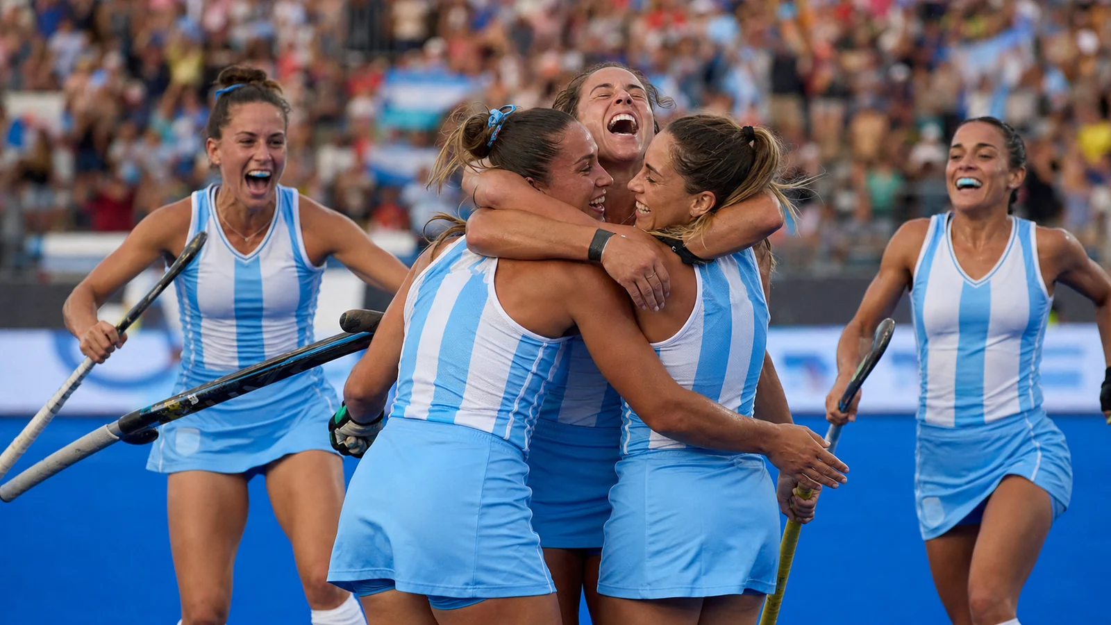 Jugadoras argentinas de hockey celebran juntas una victoria en un estadio internacional