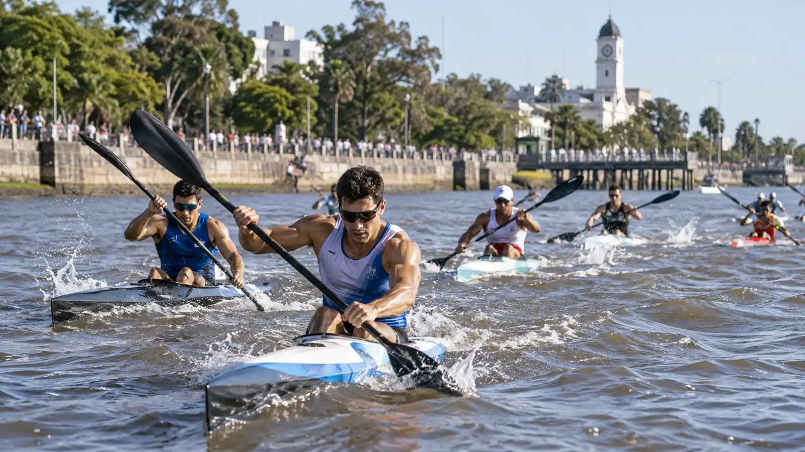 Kayakistas de competición entrenan en un río junto a una costanera urbana